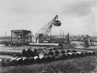 1975-55 Buizen op het terrein van de drinkwaterleiding aan de Honingerdijk. Achtergrond, de Nieuwe Maas met ...