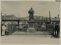 IV-70-1 Het standbeeld van Erasmus aan de Grotemarkt, uit het westen gezien, op de achtergrond het spoorwegviaduct.