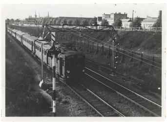 XVII-64-02 Een trein rijdt over de spoorbaan Rotterdam-Dordrecht. De foto is genomen van de Varkenoordsebrug.