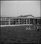 1321 Enkele kinderen in het gras op de binnenplaats. Uit een serie foto's over het Sociaal Cultureel Centrum aan de ...