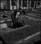 1426 Een bouwvakker maakt een voorgeproduceerd betonnen gevelelement met kozijn schoon voor de bouw van systeemwoningen ...