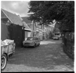17564 De Overschiese Dorpsstraat rond de Grote Kerk, met diverse (geparkeerde) auto's en een bezinepomp.