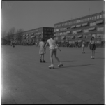 18843 Spelende kinderen, waaronder verschillende meisjes op rolschaatsen, op de Noorderhavenkade. Op de achtergrond woningen.