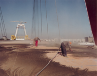 1981-677 De behandeling van het wegdek tijdens de bouw van de Willemsbrug over de Nieuwe Maas.