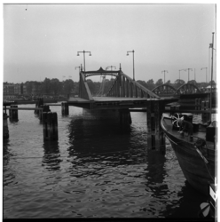 21654 Een geopende Spoorweghavenbrug, met op de achtergrond panden aan de Prins Hendrikkade. Op de voorgrond een ...