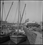 3412 Het laden en lossen van een schip aan de Spaansekade in de Oudehaven. Links de restanten van Station Beurs.