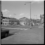 40461 De Van der Werffstraat met woningen en winkels, verkeer, gevelreclames en een reclamezuil.