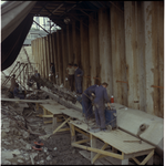 43252 Mannen in overall aan het werk bij de bouw van de nieuwe Willemsbrug. Op de achtergrond een gedeelte van de ...