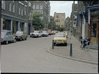 73930 De Polanenstraat, met links garagebedrijf Rijks en rechts slagerij Quant. Aan weerszijden parkeerde auto's, op de ...