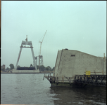 74118 Werkzaamheden voor de bouw van de Willemsbrug over de Nieuwe Maas, gezien vanaf het Bolwerk. Op de achtergrond de ...