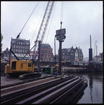 77312 Zicht op werkzaamheden voor de aanleg van de metro in de Coolhaven met behulp van heimachines. Op de achtergrond ...