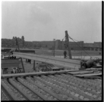 9401 Het hijsen van een betonnen balk voor de bouw van de Rozenviaduct over het Noorderkanaal. Op de achtergrond de ...