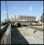 95561 Zicht op woningbouw in de omgeving van de Nassauhaven. Op de voorgrond bouwmaterialen.