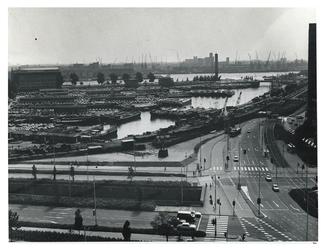 1975-1546 Overzicht vanaf het Erasmushuis aan de Coolsingel van de Leuvehaven met binnenvaartschepen, en werkzaamheden ...