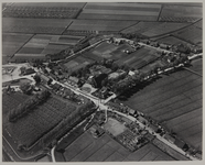 1975-1915 Luchtopname van Rhoon uit het oosten, met links de haven van Rhoon, daarvandaan naar rechtsonder de Dorpsdijk ...