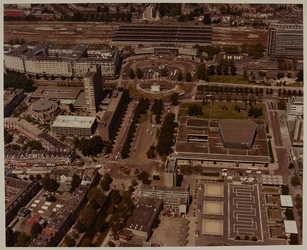 1983-1063 Luchtopname van het Stationsplein, met daarachter het Centraal Station. Op de voorgrond het Kruisplein, met ...