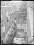 L-1611 Overzicht achterkant van woningen aan de Boomgaardsstraat. In een tuin op de voorgrond hangt wasgoed te drogen.