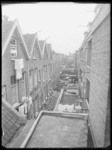 L-1616 Overzicht van de achterzijde van woningen aan de Boomgaardsstraat. Op de voorgrond hangt wasgoed te drogen, op ...