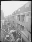L-1617 Overzicht van de achterzijde van woningen aan de Boomgaardsstraat. Op de voorgrond hangt wasgoed te drogen, op ...