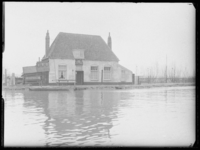L-1847 Veerhuis op de Kethelsekade aan de Delftse Schie. Aan de kade ligt een roeiboot.