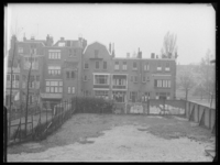 L-2464 Achterzijde van woningen aan de Robert Fruinstraat met op de voorgrond een ommuurd speelveld.