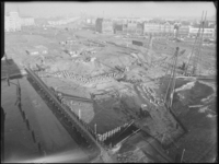 L-3879 Heimachines aan het werk bij de bouw van de Oostmolenbrug aan de Oostmolenwerf. Op de achtergrond het Oostplein ...