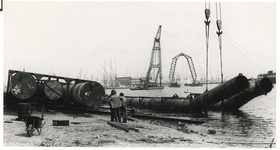 1967-354 Een zinker van de Drinkwaterleiding in de Waalhaven, voor transport naar Honingerdijk. In het midden ligt een ...