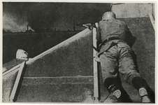 1968-252 Een Duitse soldaat met zijn geweer in de aanslag op het dak van het Poortgebouw. Op de achtergrond rook en ...