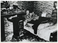 1968-291 Een moeder en twee kinderen houden elkaar warm in bed in een woning in Den Haag tijdens de hongerwinter.