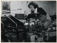 1977-3644 Een jonge vrouw aan het werk in een drukkerij tijdens de bezettingsjaren in de Tweede Wereldoorlog.