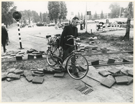 1980-71 Fietser tilt zijn fiets over de door stakers opgebroken weg bij de Waalhaven.