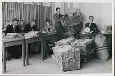 XXXIII-574-00-03-3 Leden van de Schade-Enquête-Commissie in de postkamer van het Beursgebouw met de binnengekomen ...