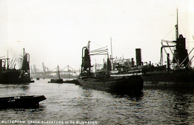 PBK-1987-1338 Vrachtschepen en binnenvaartschepen met elevators voor het overslaan van graan in de Rijnhaven.