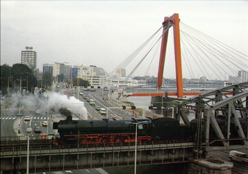 PBK-1996-122 Een locomotief passeert op 24 september 1993 (de laatste dag van het bovengronds treinverkeer) de ...