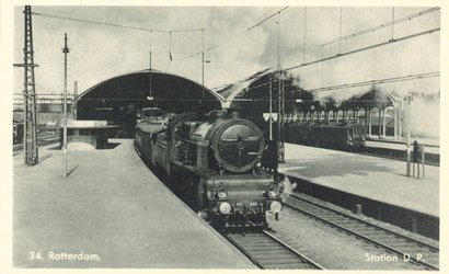 PBK-6597 Onder de negentiende-eeuwse overkapping van beide perrons van station Delftse Poort vertrekken treinen.