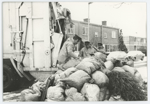 2003-219-1-168-D Vuilnismannen gooien een berg vuilniszakken en een kerstboom in een vuilniswagen in de Harkulo in Pendrecht.