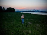 2012-17 Man staat in Pernis op de oever van de Nieuwe Maas. De foto is gemaakt in opdracht van De Kracht van Rotterdam ...