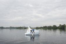 2014-22 Twee jongeren hangen op de zijkant van een omgeslagen zeilboot op de Bergse Plassen. De foto is gemaakt in ...