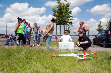 2014-39 Groep mensen kijkt naar man met modelvliegtuigen. De foto is gemaakt in opdracht van De Kracht van Rotterdam (DKVR).