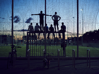 2017-4 silhouet van jongeren die staan en zitten op de lat van een doel op een voetbalveld. De foto is gemaakt in ...