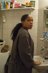 2019-17 Portret van een jonge vrouw bij een wastafel in een badkamer. Uit een serie van vier portretten over gekleurde ...