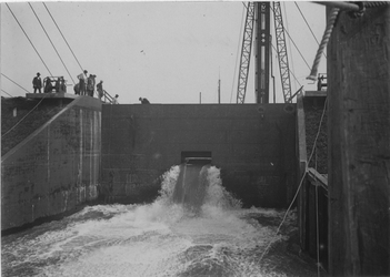 1971-1052 Inlaten van water in de bouwput tijdens de aanleg van de kademuur in de IJselhaven.