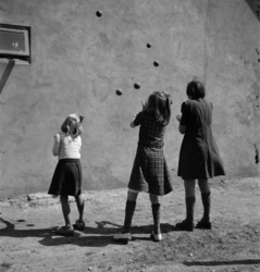1972-17008 Meisjes kaatsenballen tegen een muur.