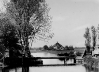 1976-607 Boezemwater bij molen 'De Valk' (links) vanuit het oosten. Op de achtergrond een rond bouwwerk (bungalow) ...