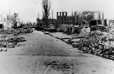 1977-1642 Gezicht op een door het Duitse bombardement van 14 mei 1940 verwoeste straat. Gedeeltelijk zijn losse stenen ...