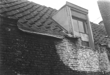 1980-1797 Gezicht in de Kalverstraat. Het beschadigd boven gedeelte van een huis met zolderraam.