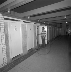 1980-3895 Het gemeentebadhuis aan de Bruijnstraat nummer 47. De opzichter maakt een douchehok schoon.