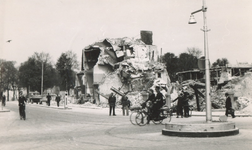 1983-169 Puinresten in de Rederijstraat na het bombardement van 14 mei 1940. Over straat fietsen en wandelen mensen. Op ...