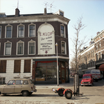 1983-3117 Hoekpand aan de Ketenstraat. Een groot reclamebord op buitenmuur geeft te lezen: E. klop. Uw adres voor ...