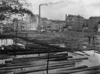 1983-500 Balken hout van houthandel J. van Schijndel (gevestigd aan de Admiraliteitskade 47) liggen in het water van ...